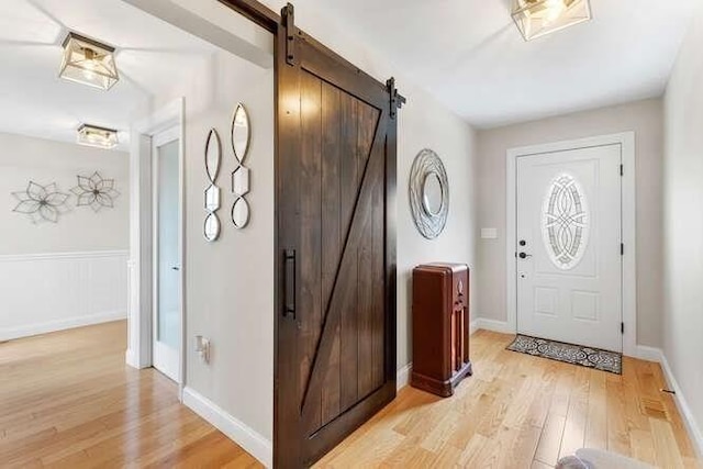 entrance foyer with a barn door and light wood-type flooring