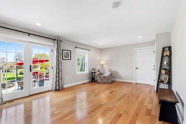 living area featuring light wood finished floors, baseboards, and recessed lighting