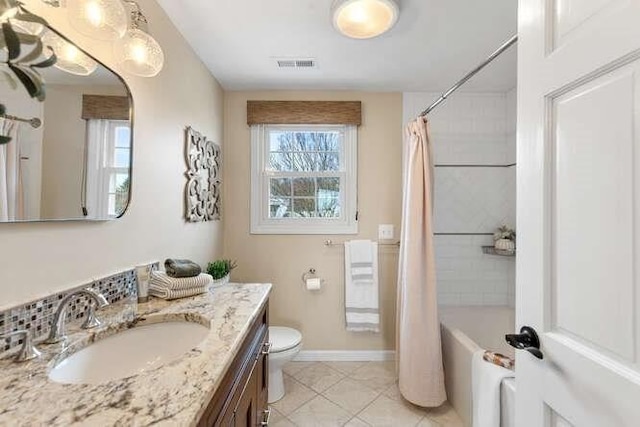 full bathroom featuring toilet, vanity, tile patterned flooring, baseboards, and shower / bathtub combination with curtain
