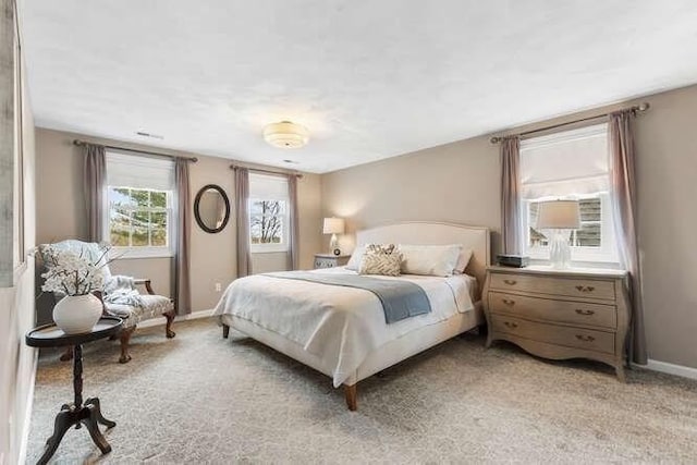 bedroom with light colored carpet and baseboards
