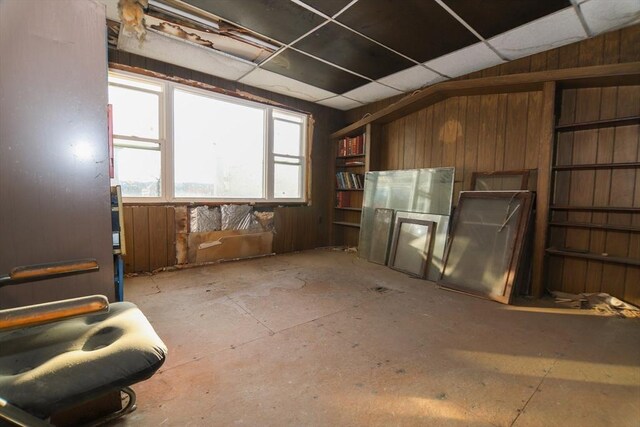 miscellaneous room with a paneled ceiling and wooden walls