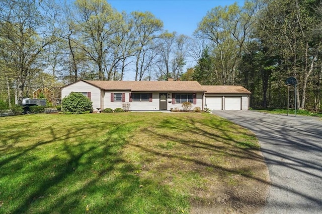 single story home with a chimney, a garage, driveway, and a front yard