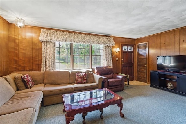 living room with wood walls, ornamental molding, and carpet
