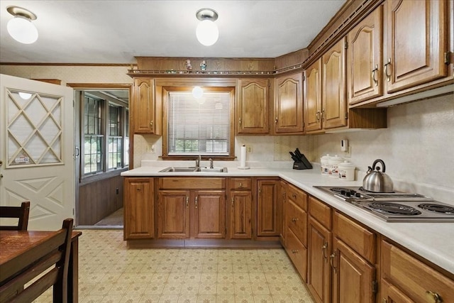 kitchen featuring light countertops, light floors, a sink, and stainless steel electric cooktop