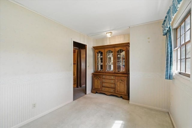 unfurnished room with light carpet and wainscoting