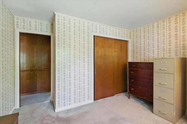 carpeted bedroom with a closet, ornamental molding, and wallpapered walls