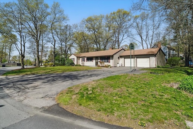view of front of house with a garage, a front lawn, and driveway