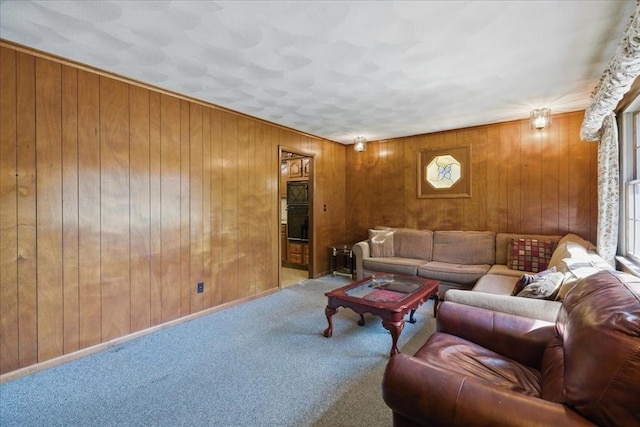 carpeted living area with wood walls