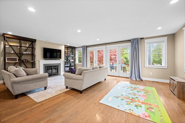 26 Downing Rd, Lexington, MA 02421 - living room with light wood-style floors, baseboards, a fireplace with flush hearth, recessed lighting, and french doors