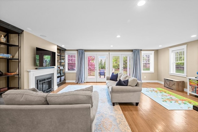 26 Downing Rd, Lexington, MA 02421 - living area with light wood-style flooring, a glass covered fireplace, baseboards, french doors, and recessed lighting