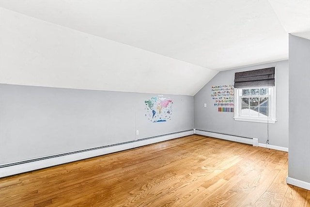 bonus room featuring vaulted ceiling, light hardwood / wood-style floors, and baseboard heating