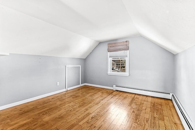 bonus room featuring lofted ceiling, hardwood / wood-style flooring, and baseboard heating