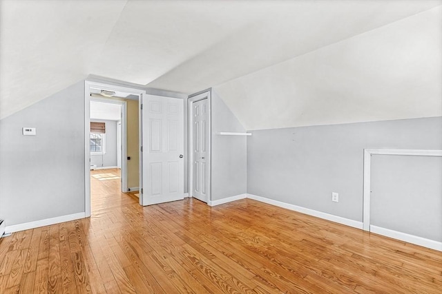 additional living space with lofted ceiling and light wood-type flooring