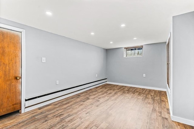 empty room with a baseboard heating unit and light wood-type flooring