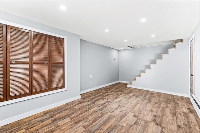 basement featuring a baseboard radiator and hardwood / wood-style floors