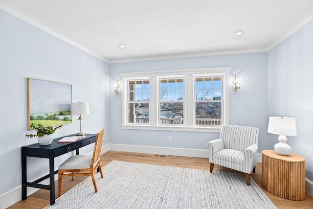 living area featuring baseboards, wood finished floors, and ornamental molding