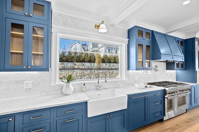 kitchen featuring a sink, blue cabinetry, custom exhaust hood, double oven range, and crown molding