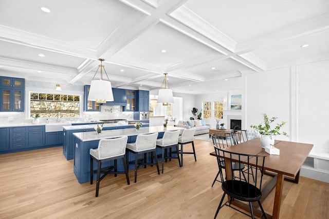 kitchen with a wealth of natural light, a sink, a large island, and blue cabinetry