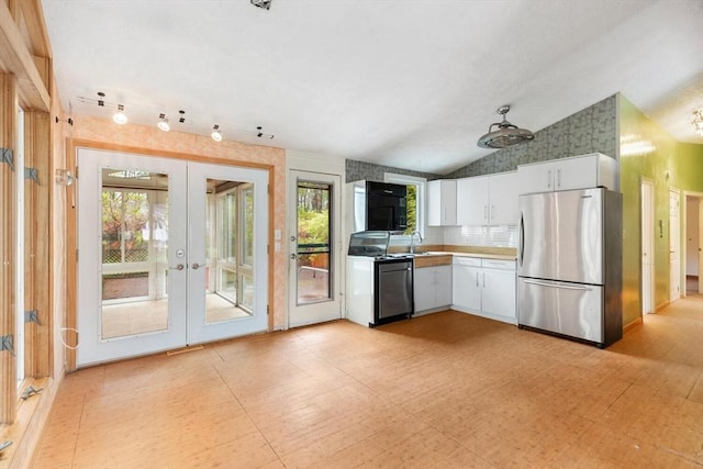 kitchen with freestanding refrigerator, stove, black microwave, french doors, and white cabinets
