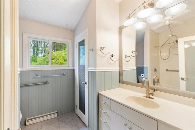 full bathroom with a baseboard radiator, marble finish flooring, vanity, wainscoting, and shower / washtub combination