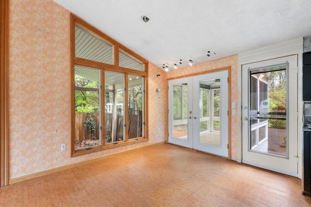 doorway to outside with french doors, wallpapered walls, baseboards, rail lighting, and tile patterned floors