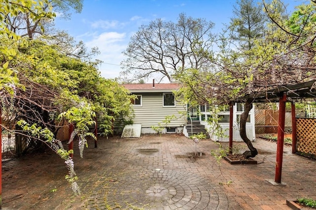 rear view of property with a patio and fence