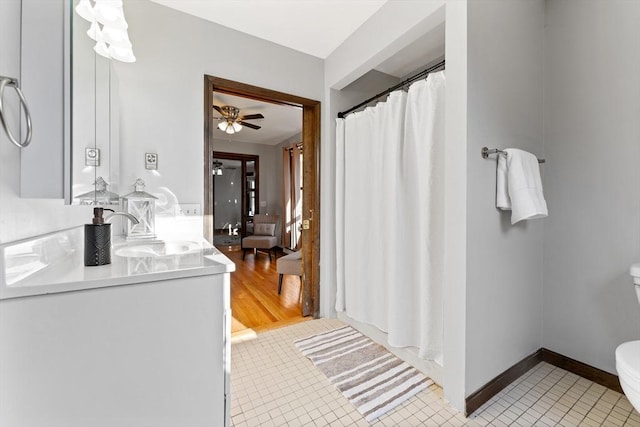 bathroom featuring ceiling fan, tile patterned flooring, vanity, a shower with curtain, and toilet