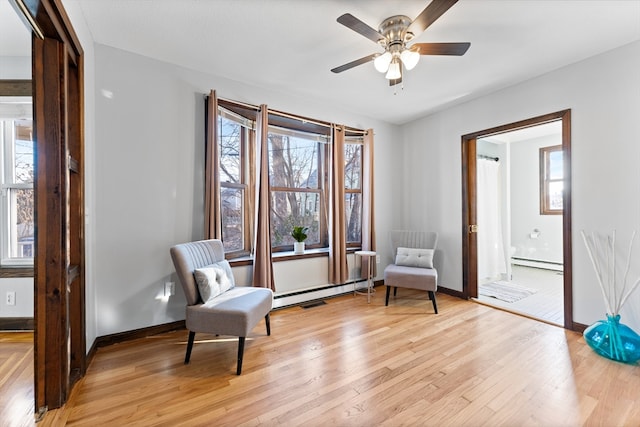 sitting room featuring ceiling fan, a baseboard radiator, and light hardwood / wood-style flooring