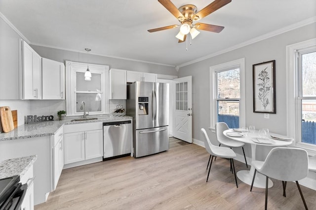 kitchen with decorative light fixtures, white cabinetry, light stone counters, stainless steel appliances, and light wood-type flooring