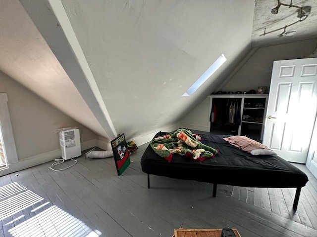 bedroom featuring wood-type flooring and lofted ceiling with skylight