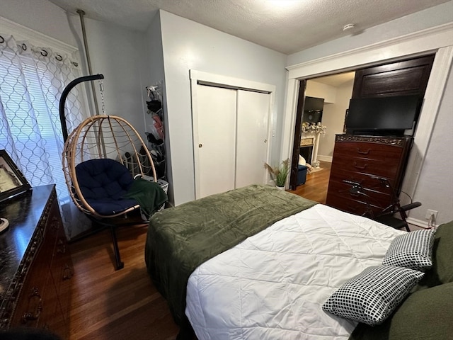 bedroom featuring hardwood / wood-style flooring, a textured ceiling, and a closet