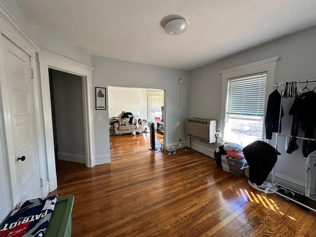 interior space with dark wood-type flooring and a wall mounted AC