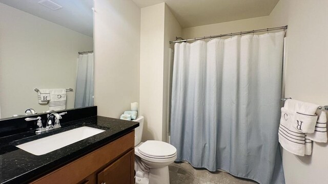 bathroom with toilet, vanity, and a shower with curtain