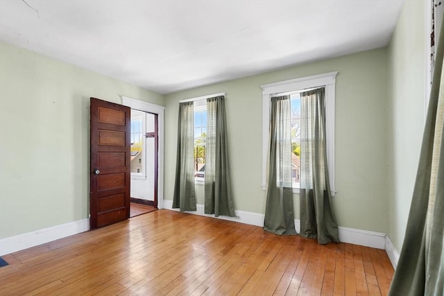 unfurnished room featuring baseboards and light wood-style flooring