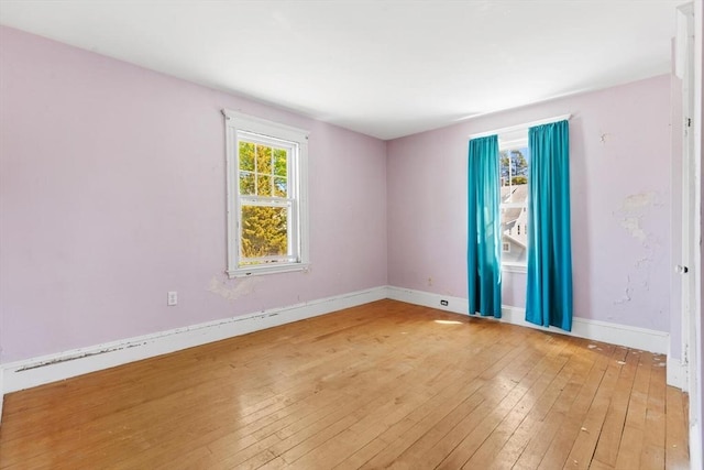 spare room featuring baseboards and light wood-style flooring