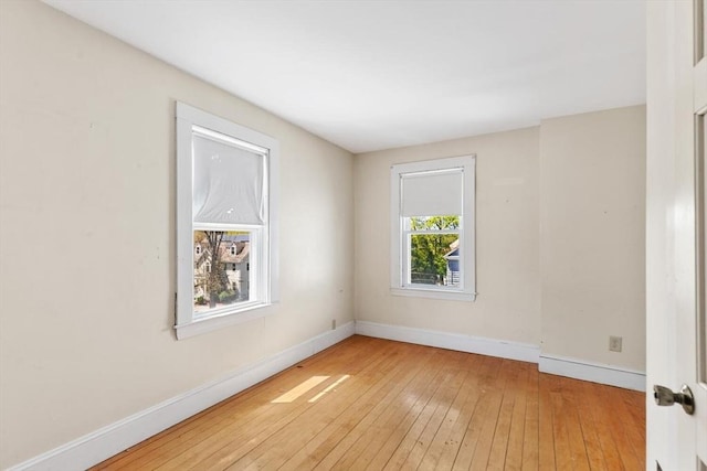 empty room with baseboards and light wood-type flooring