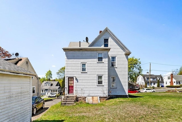 back of property with a yard and a chimney