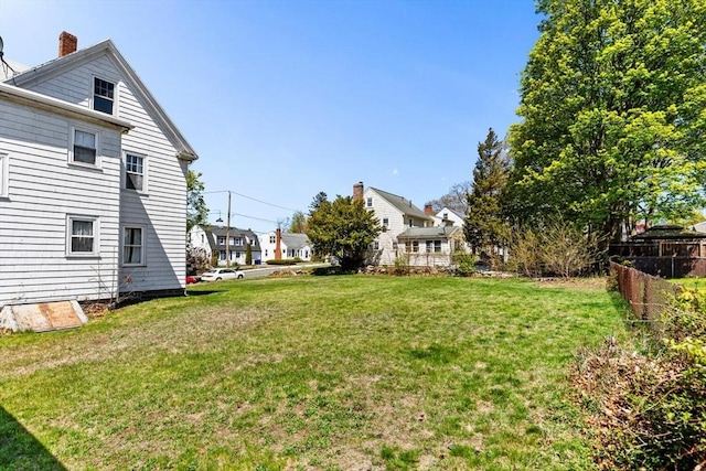 view of yard featuring fence and a residential view
