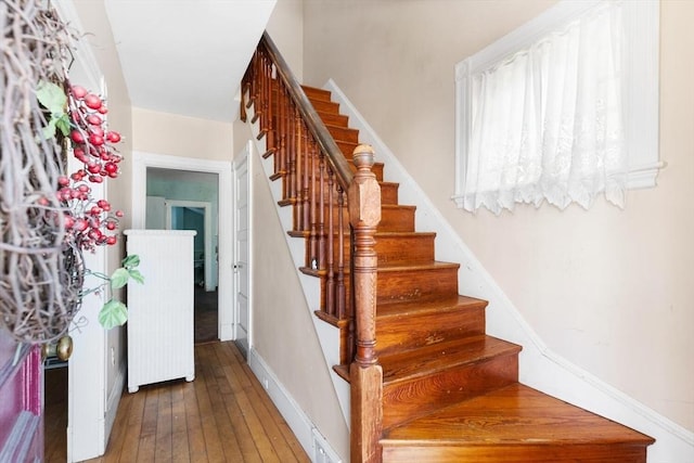 stairway with baseboards and hardwood / wood-style flooring