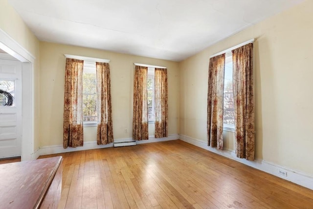 empty room with baseboards and hardwood / wood-style floors