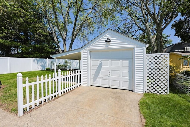 garage with driveway and a detached garage