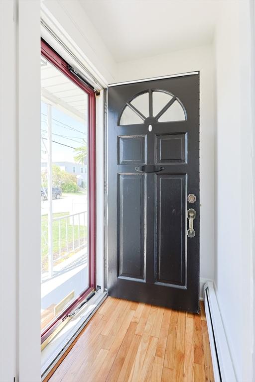 entryway featuring a baseboard heating unit and light wood-style floors