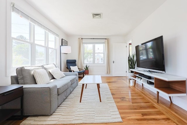 living area with light wood-style flooring and baseboards