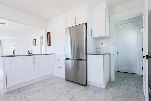 kitchen featuring freestanding refrigerator and white cabinets