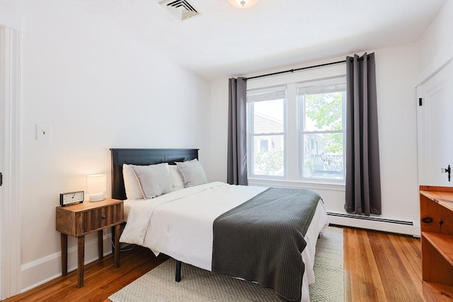 bedroom featuring a baseboard radiator and light wood finished floors