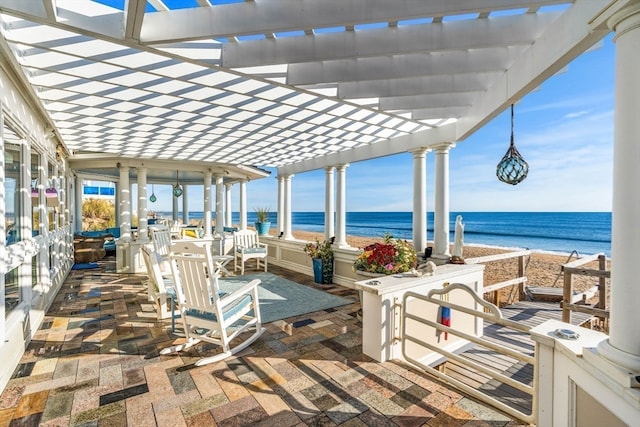 view of patio featuring a pergola and a water view