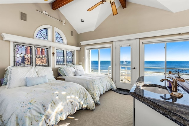 bedroom with beamed ceiling, a water view, and access to outside