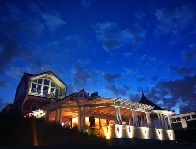 property exterior at twilight featuring a pergola