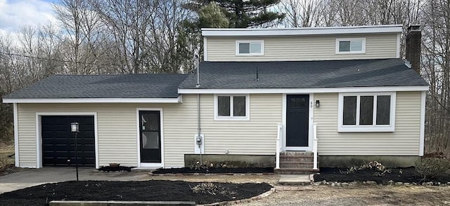 view of front of house with driveway, entry steps, an attached garage, a shingled roof, and a chimney