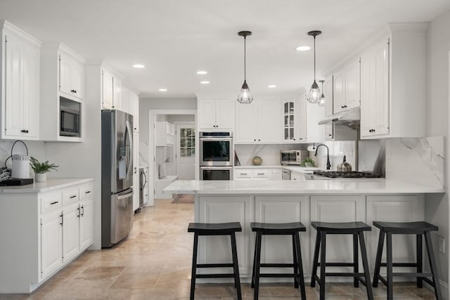 4 Country Way, Hopkinton, MA 01748 - kitchen featuring stainless steel appliances, a peninsula, white cabinets, under cabinet range hood, and recessed lighting